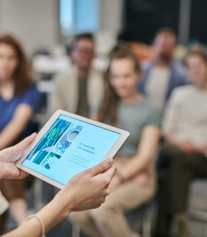 Business seminar with participants focused on a tablet presentation in an office setting.